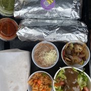 Photo of Lucha Libre Gourmet Taco Shop - San Diego, CA, United States. Both our burritos with sides and salsas.
