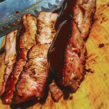 The Sweet Pigs - two slices of meat on a cutting board - Caterers Near Me The Sweet Pigs - two slices of meat on a cutting board - Caterers Near Me