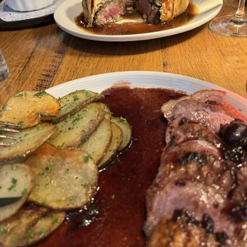 Cuisine & Wine Bistro - Duck and potatoes.  Chrerry sauce.  In the foreground, filet mignon wellington and gratin potatoes - Wine Bars Near Me - Chandler, Arizona