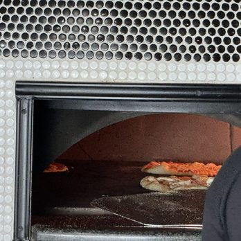 Strong’s Brick Oven Pizzeria - a man taking a pizza out of the oven - Pizza Near Me - Cincinnati, Ohio Strong’s Brick Oven Pizzeria - a man taking a pizza out of the oven - Pizza Near Me - Cincinnati, Ohio