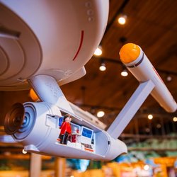 The Great Rocky Mountain Toy Company - Large spacecraft model displayed inside a colorful toy store, creating an exciting space-themed atmosphere surrounded by toys...