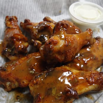 Village Pizza - a plate of chicken wings with sauce - Pizza Near Me - Blakely, Georgia