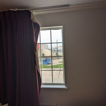 Rodeway Inn - Lovely view of nearby dumpster & shopping cart of trash around falling-down curtains (that smell like an old ashtray) - Hotels Near Me - Stephenville, Texas