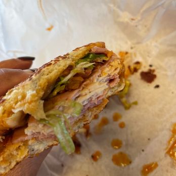 Quiznos - a hand holding a half eaten sandwich - Sandwiches Near Me - Fowler, California