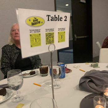 The Dinner Detective Interactive Murder Mystery Dinner Show - a woman sitting at a table - Performing Arts Near Me - Minneapolis, Minnesota The Dinner Detective Interactive Murder Mystery Dinner Show - a woman sitting at a table - Performing Arts Near Me - Minneapolis, Minnesota
