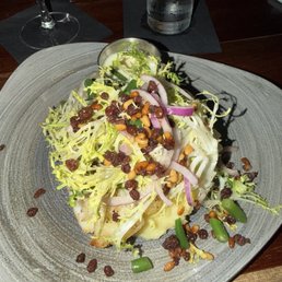 The baked cod with pine nuts black currents topped with frise and mashed potatoes I had the burre Blanc sauce on the side The baked cod with pine nuts black currents topped with frise and mashed potatoes I had the burre Blanc sauce on the side