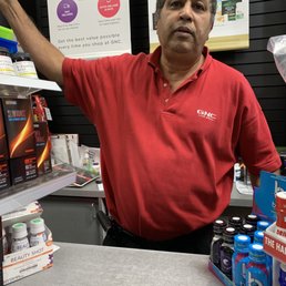 a man in a red shirt at a store counter a man in a red shirt at a store counter