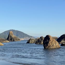 Battle Rock Wayfinding Point - The view of rocks on Port Point Beach, looking south with Humbug Mountain in the background.