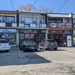 Looking at the restaurant from the sidewalk by the street on the far side of the strip mall parking lot. April 2022