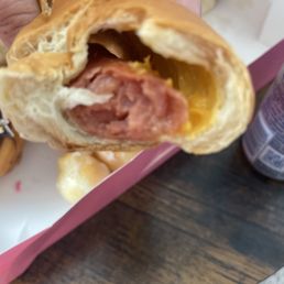 a hand holding a hot dog