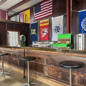 Burks Brothers Brewing - a bar with stools and flags - Breweries Near Me - Bryant, Arkansas Burks Brothers Brewing - a bar with stools and flags - Breweries Near Me - Bryant, Arkansas