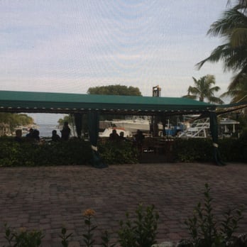 Buzzard's Roost Grill & Pub - Outdoor covered patio; evening view down canal to Atlantic Ocean - Seafood Near Me - Key Largo, Florida Buzzard's Roost Grill & Pub - Outdoor covered patio; evening view down canal to Atlantic Ocean - Seafood Near Me - Key Largo, Florida