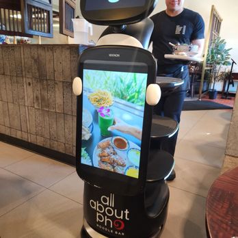 All About Pho - Mini robot brings food to the table. That's Tom in the back - Vietnamese Near Me - Cerritos, California All About Pho - Mini robot brings food to the table. That's Tom in the back - Vietnamese Near Me - Cerritos, California