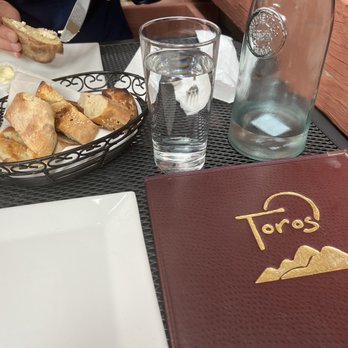 Toros - Seated in patio with menus, bread, and bottle of water - Mediterranean Near Me - Montclair, New Jersey