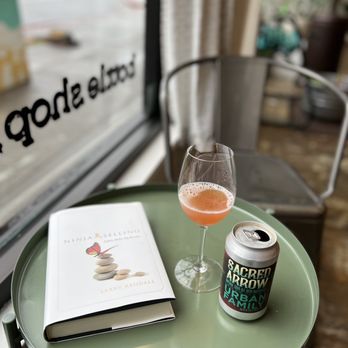 Bay Grape - a glass of wine and a book on a table - Beer, Wine & Spirits Near Me - Oakland, California