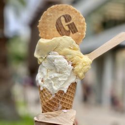 a hand holding a waffle cone filled with ice cream a hand holding a waffle cone filled with ice cream