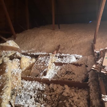 Insulation Pros - Over kitchen - A photo of an attic shows loose insulation material spread across the floor and some insulation on the wooden framing. The attic has a sloped ceiling with visible wooden beams. - Insulation Installation Near Me - Independence, Missouri
