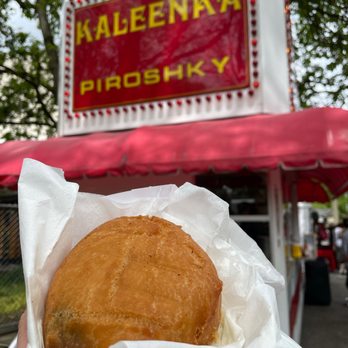 Kaleenka Piroshky - a person holding a sandwich - Food Stands Near Me - Puyallup, Washington