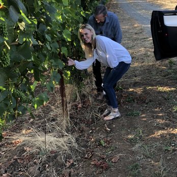 At Root - Corwynn giving Sherri a grape lesson. - Wine Tours Near Me At Root - Corwynn giving Sherri a grape lesson. - Wine Tours Near Me