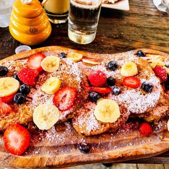 Cafe Bubamara - multi-grain & fresh fruit Prženice (homemade French toast with a Balkan twist) on a wooden platter. - Modern European Near Me - Clifton, New Jersey