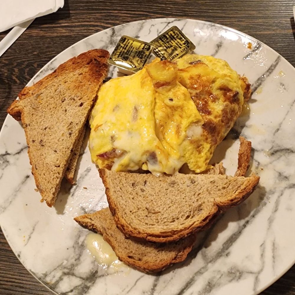 Bacon and cheese omelet with wheat toast. Bacon and cheese omelet with wheat toast.