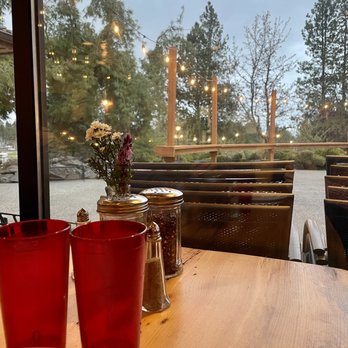 Embers By The Green - a wooden table with two red cups on it - Pizza Near Me - Post Falls, Idaho Embers By The Green - a wooden table with two red cups on it - Pizza Near Me - Post Falls, Idaho