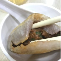 Pan fried beef bun, piping hot juice inside the bun. Pan fried beef bun, piping hot juice inside the bun.