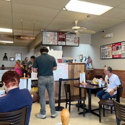 Gus's Hot Dogs - Line and dining room at Gus's Hot Dogs in Irondale, Alabama. On the menu board are pink stickers indicating savings by paying cash.