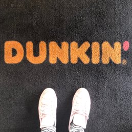  a person standing in front of a dunkin rug