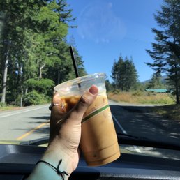 a hand holding a cup of iced coffee a hand holding a cup of iced coffee