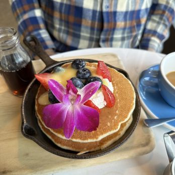 Bluestone Lane Upper West Side Café - Lemon ricotta pancakes with edible flower - Coffee & Tea Near Me - New York, New York Bluestone Lane Upper West Side Café - Lemon ricotta pancakes with edible flower - Coffee & Tea Near Me - New York, New York