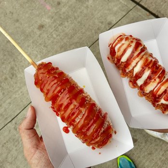 Chung Chun Rice Dog - a person holding a hot dog on a stick - Hot Dogs Near Me - Toronto, Ontario Chung Chun Rice Dog - a person holding a hot dog on a stick - Hot Dogs Near Me - Toronto, Ontario
