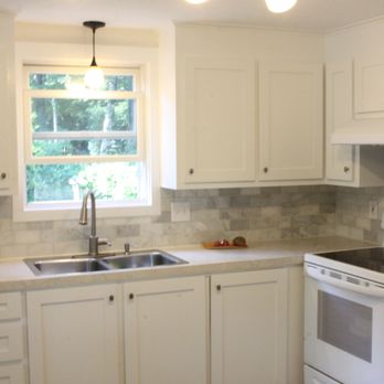 Petrone construction - a kitchen with white cabinets and white appliances - General Contractors Near Me - Cape Elizabeth, Maine
