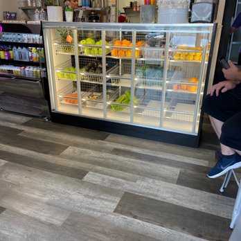 The Juice Pod - a man sitting in a chair in front of a refrigerated display case - Juice Bars & Smoothies Near Me - Springfield, Pennsylvania The Juice Pod - a man sitting in a chair in front of a refrigerated display case - Juice Bars & Smoothies Near Me - Springfield, Pennsylvania