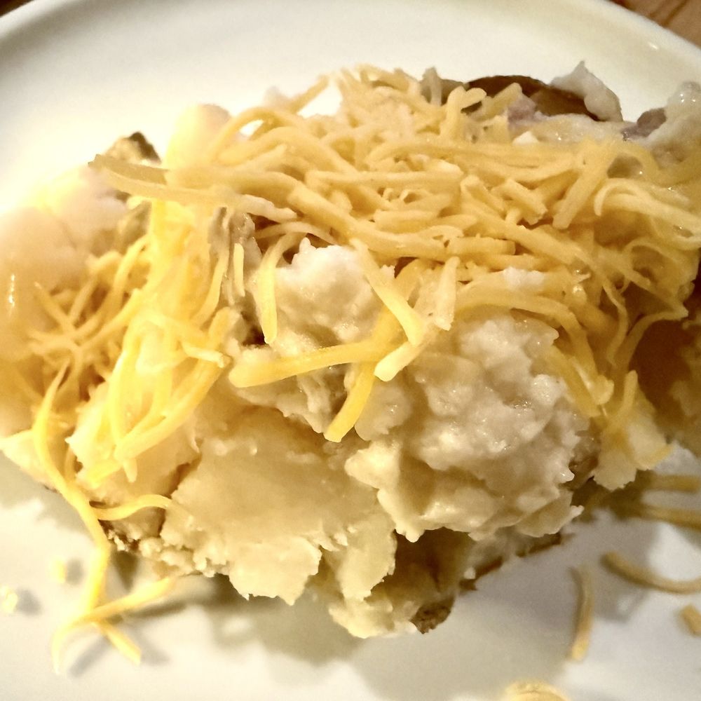 Rare 3001 - A piece of baked potato dressed with mashed potato and shredded cheese - Steakhouses Near Me - Rochester, New York Rare 3001 - A piece of baked potato dressed with mashed potato and shredded cheese - Steakhouses Near Me - Rochester, New York