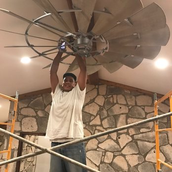 Precise Painting - a man working on a ceiling fan - Painters Near Me - San Angelo, Texas