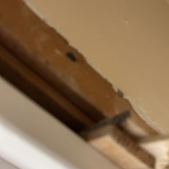 Custom Work in Older Homes - Behind pantry door(above and behind wall) unfinished, shims sticking out. - General Contractors Near Me