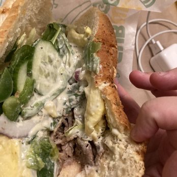 Subway - a hand holding a half eaten sandwich - Fast Food Near Me - New Minas, Nova Scotia