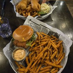 Fish burger with sweet potato fries. Across is the fish and chips.