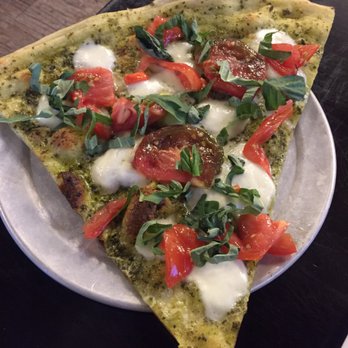 Crust Pizzeria - "Big slice" of basil pizza which has heirloom tomatoes, mozzarella, and fresh basil. It fed 2 people and was super fresh. - Pizza Near Me - Solana Beach, California