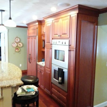 Merrimack Construction Group - a kitchen with wood cabinets - General Contractors Near Me - Tyngsboro, Massachusetts