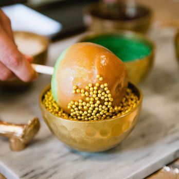 The Cupcake Bar - Caramel Apple Bartender dips custom caramel apple in toppings at corporate event in Austin, Texas. - Desserts Near Me The Cupcake Bar - Caramel Apple Bartender dips custom caramel apple in toppings at corporate event in Austin, Texas. - Desserts Near Me