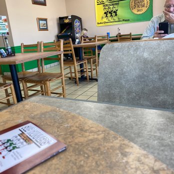 Sub Runners - a man sitting at a table in a restaurant - Pizza Near Me - Salisbury, Maryland Sub Runners - a man sitting at a table in a restaurant - Pizza Near Me - Salisbury, Maryland