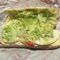 a sandwich with lettuce and tomatoes