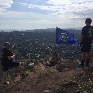 Photo of Cahuenga Peak - Los Angeles, CA, United States. Father originally from Mexico and his son, looking at the Flag of Unity