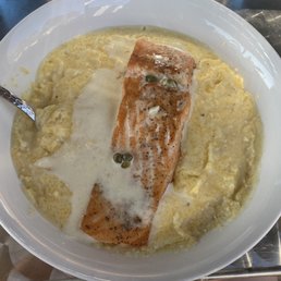 Salmon and grits with a cream sauce and capers