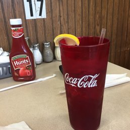 a coke glass with a straw and a lemon wedge