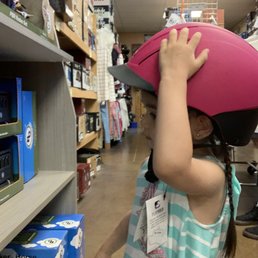 Trying on her new riding helmet Trying on her new riding helmet