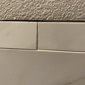 Rock Your House Remodeling - You can clearly see that the tile in the wainscoat and pony wall was laid down unevenly - General Contractors Near Me