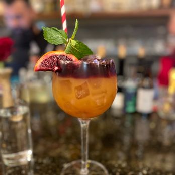 Cavas - a glass of orange juice with a straw and garnish - Spanish Near Me - Milwaukee, Wisconsin